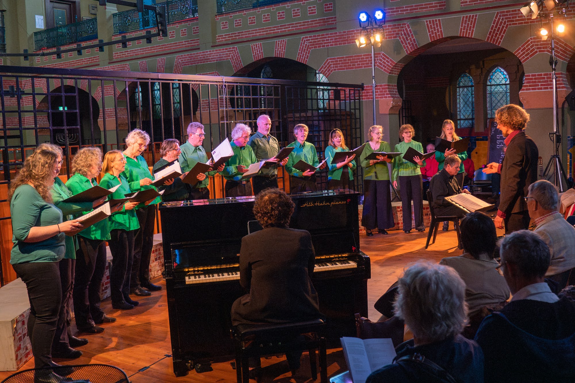 STEK-koorleden in groene kleding zingen
